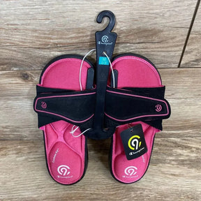 Overhead view of pink Champion memory-foam toddler slide sandals with black adjustable straps on wood background, size 2/3Y